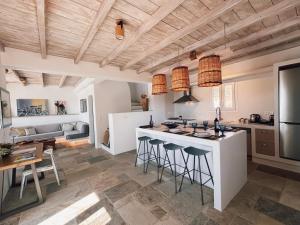 a kitchen with a island with bar stools at Elysian Villas Ios in Ios Chora