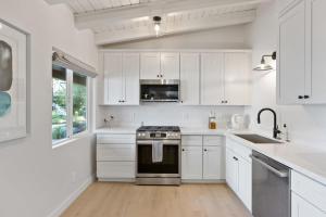 een witte keuken met een fornuis en een wastafel bij South Lake Chalet by Heavenly in South Lake Tahoe