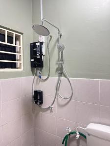 Humaira Homestay Teluk Intan في تيلوك إنتان: وجود شطاف بالحمام بجانب المرحاض