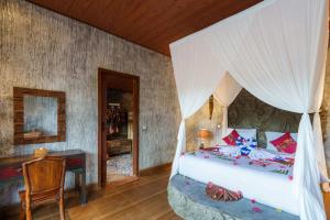 ein Schlafzimmer mit einem Himmelbett in der Unterkunft Royal Agung Amertha Villa in Bedahulu + 33 Fotos