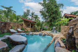 ein Pool mitten in einem Garten in der Unterkunft Royal Agung Amertha Villa in Bedahulu