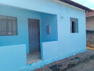 a blue and white house with a door at Casa simples em cunha in Cunha