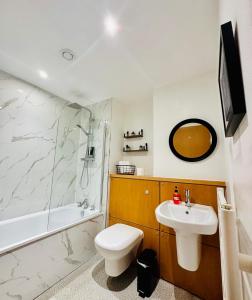 a bathroom with a sink and a toilet and a shower at Harbour Horizons in Edinburgh +11 photos