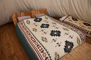 a bed with a blanket on top of it at Logement insolite glamping tipi et lodge Var Grimaud in Grimaud +32 photos
