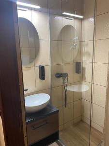 a bathroom with a sink and a glass shower at FoRest Apartment 