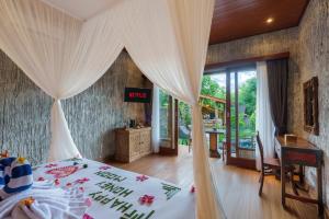 ein Schlafzimmer mit einem Bett und einem Schreibtisch in einem Zimmer in der Unterkunft Royal Agung Amertha Villa in Bedahulu