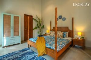 a bedroom with a bed with a wooden canopyved bed sidx sidx sidx at EKOSTAY - Assa Villa in Marna