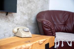 a telephone sitting on a table next to a chair at FoRest Apartment in Mokra Gora