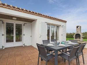 Séjour à la campagne pour 6 في Commequiers: طاولة وكراسي على فناء مع مدفأة