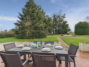 Séjour à la campagne pour 6 في Commequiers: طاولة سوداء وكراسي على الفناء