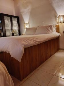 een groot bed met een houten frame in een kamer bij Rooster Retreat in Aridaía