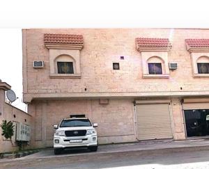a white truck parked in front of a building at شقق مفروشة الحارث بن عمرو in AlUla +3 photos