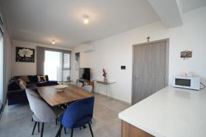 Larnaca Salt Lake Gem, Airy 2 BDRM Apartment في لارنكا: مطبخ وغرفة معيشة مع طاولة وكراسي