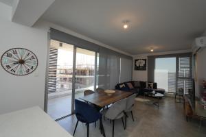 Larnaca Salt Lake Gem, Airy 2 BDRM Apartment في لارنكا: غرفة طعام وغرفة معيشة مع ساعة على الحائط