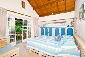 a bedroom with a large blue bed with blue pillows at Villa Easternwind in Pointe d'Esny