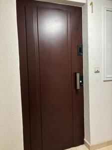 eine große braune Tür in einem Gebäude mit in der Unterkunft Dulzena Stay Apartments in A Coruña