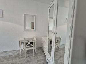 espejo en una habitación con mesa y silla en Mikra Homes24 in Chemnitz, en Chemnitz