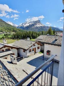 a view of some buildings with mountains in the background at Chesa Tre Piz in Maloja