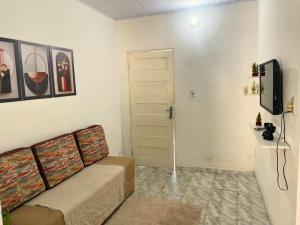 een woonkamer met een bank en een tv bij AeroSol Espaço Inteiro - Casa in Aracaju