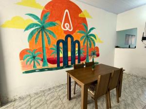 een eetkamer met een tafel en een schilderij aan de muur bij AeroSol Espaço Inteiro - Casa in Aracaju +10 foto's