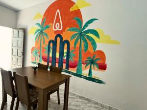 een eettafel met een schilderij aan de muur bij AeroSol Espaço Inteiro - Casa in Aracaju
