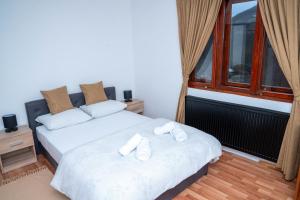 a bedroom with two beds and a window at FoRest Apartment in Mokra Gora