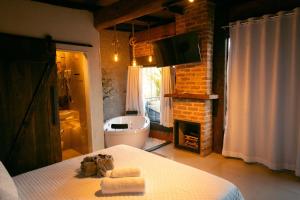 un bagno con un letto e un bagno con un camino di Herança do Vovô02 a Domingos Martins Altre 23 foto