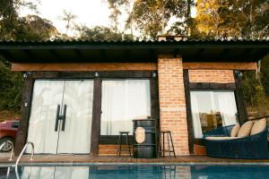 una piccola casa con una piscina di fronte di Herança do Vovô02 a Domingos Martins