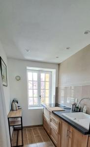 Saint-PointにあるLa Chenevièreのシンクと大きな窓のあるキッチン