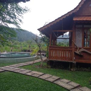 a house with a porch next to a swimming pool at Green vanilla Suite 2 in Silebeng