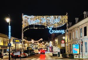 a city street with christmas lights and cars parked on the street at Le VeUvE cLicQuOt in Épernay +9 photos
