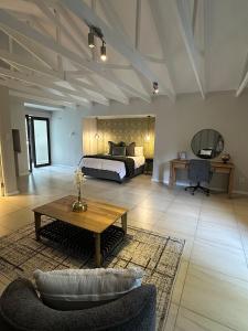 - une grande chambre avec un lit et une table basse dans l'établissement Luxe Stay Somerset West 4, à Somerset West