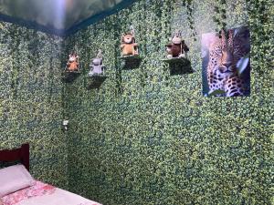 a bedroom with a green wall with animals on it at Camping estrela Ubatuba in Ubatuba