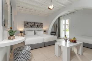 a white bedroom with a bed and a table at Naxos Resort in Naxos Chora +170 photos