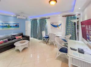 a living room with a couch and a table and chairs at Garden Condo in Sosúa