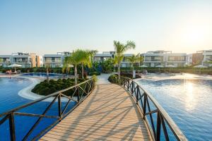 a bridge over a pool at a resort at Spacious & Bright 2BR Apartment, 5min to Beach in Boghaz