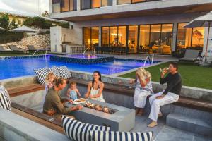 a group of people sitting next to a swimming pool at Bella Rocca in Gun Bay