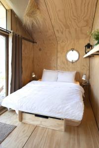 Huisje met uitzicht op de polder aan het water في Oud-Ade: غرفة نوم بسرير كبير في غرفة صغيرة