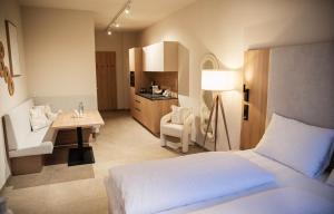 a bedroom with a bed and a desk and a kitchen at Appartement Chalet Saalbach in Saalbach Hinterglemm