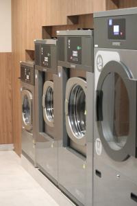 CASA ROMA Hostel Boutique في تاراغونا: صف من الغسالات في غرفة الغسيل