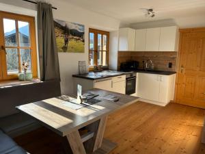 a kitchen with a wooden table in a room at Wimmerhof - Appartement Bergsonne in Breitenbach am Inn