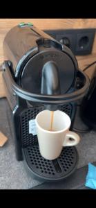 een koffiezetapparaat met een kopje koffie erin bij Wimmerhof - Appartement Bergsonne in Breitenbach am Inn