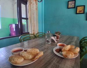 een tafel met twee borden eten en twee kommen soep bij Green Hill Home in Mirik
