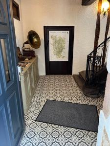 a hallway with a black door and a tile floor at Chez Simone et Marguerite in Luzy