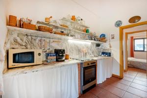 a kitchen with a counter top with a microwave at Villa Ada in Cozze +15 photos