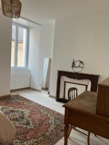 a living room with a table and a fireplace at Chez Simone et Marguerite in Luzy