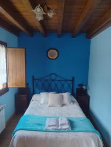 Un dormitorio azul con una cama con dos toallas encima. en Casa Angelita, en Intriago 7 fotos más