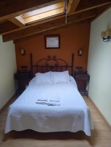 Un dormitorio con una gran cama blanca con dos toallas encima. en Casa Angelita, en Intriago