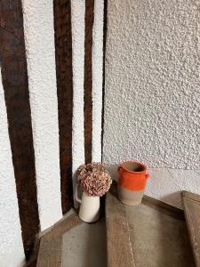 two vases sitting on a ledge next to a wall at Chez Simone et Marguerite in Luzy