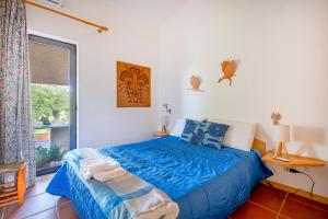 a bedroom with a bed with blue sheets and a window at Villa Ada in Cozze